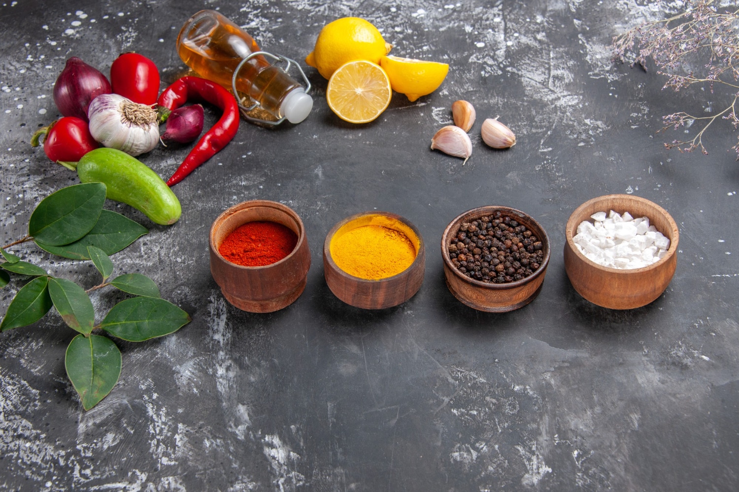 A photograph of different spices, fruits, and vegetable on a table.
