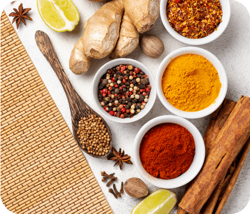 A photograph of different spices, fruits, and vegetable on a table.