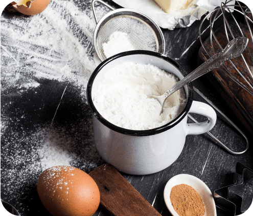 A zenith photograph of flour, eggs, and different ingredients on a table.